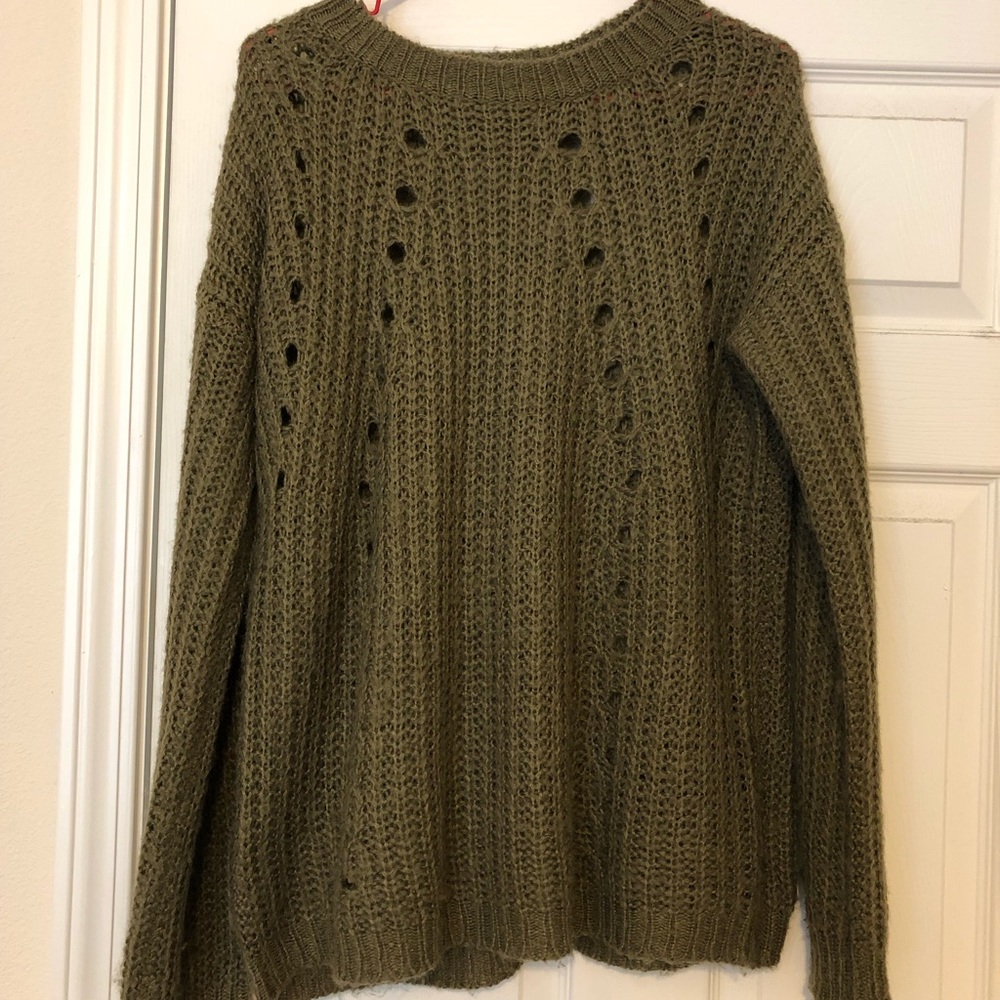 A long sleeve, olive colored, hole ripped sweater
